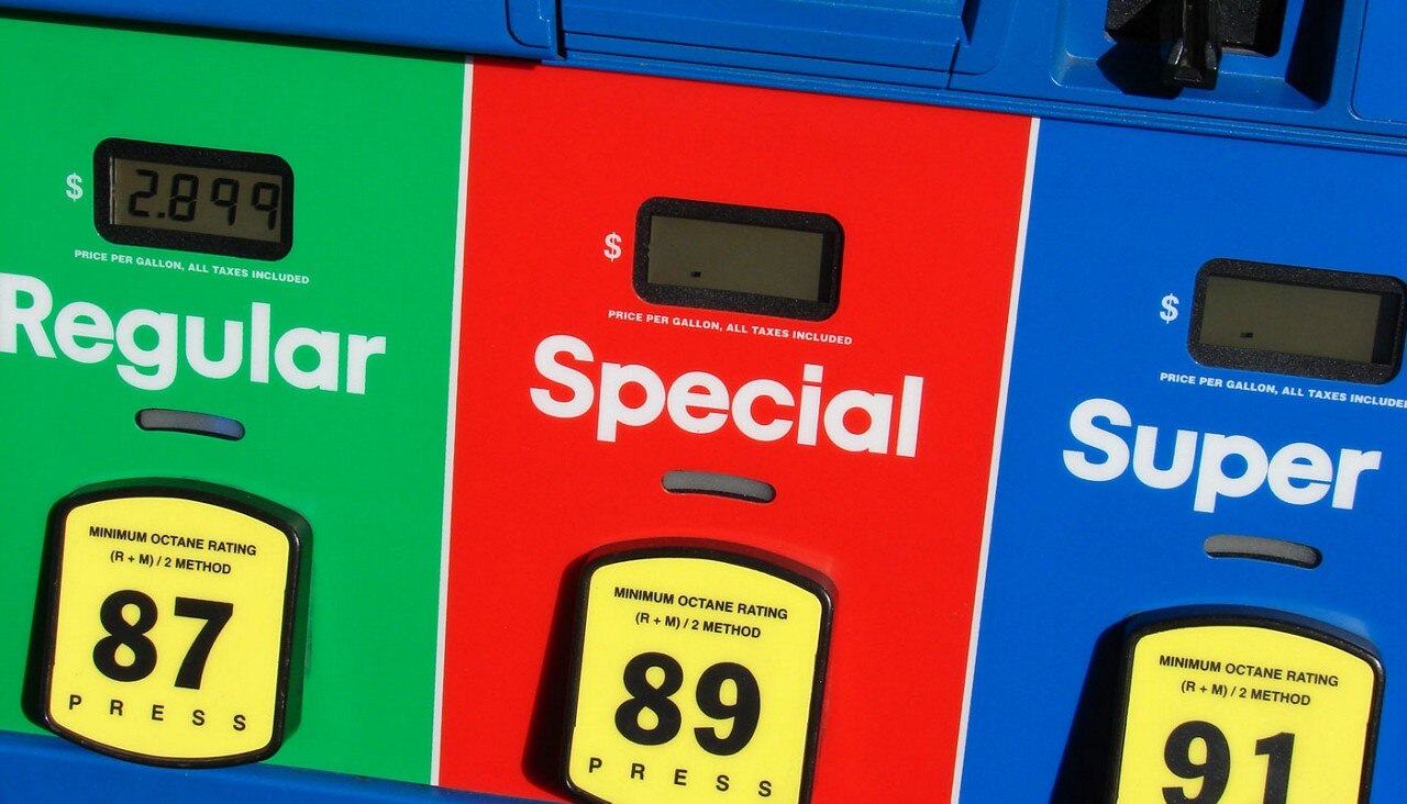 A close-up view of a gas station fueling station with Regular, Special and Super noted on the gas handles.