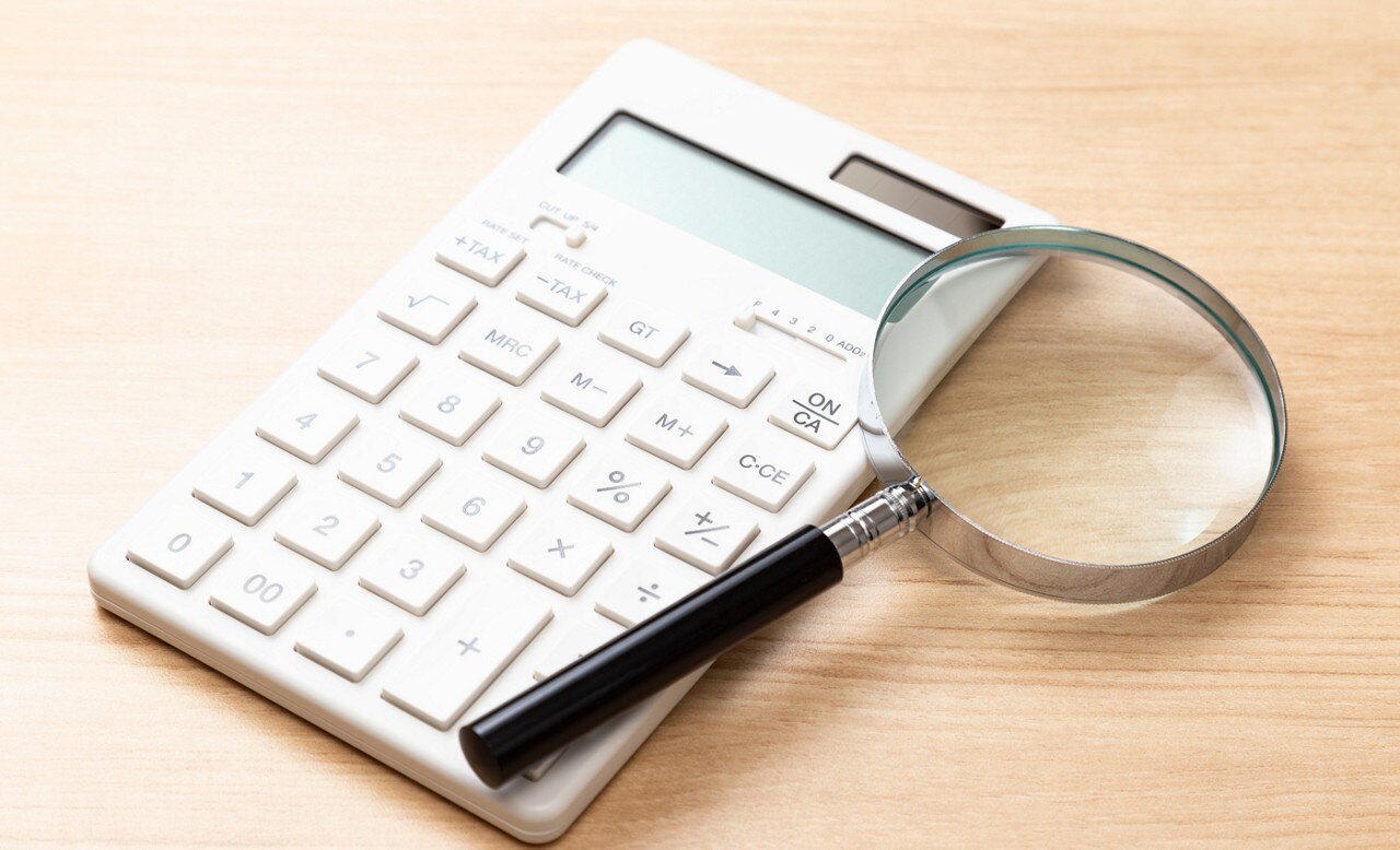 Calculator and magnifying glass on table